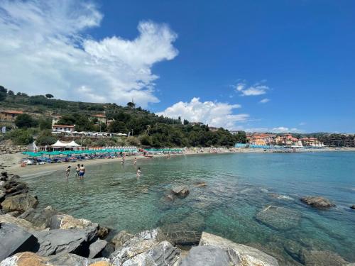 a beach with a group of people in the water at Apartment Cielsereno - SLR246 by Interhome in Costarainera