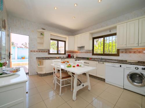 una cucina bianca con tavolo e lavandino di Holiday Home Casa Sandra by Interhome a Albir