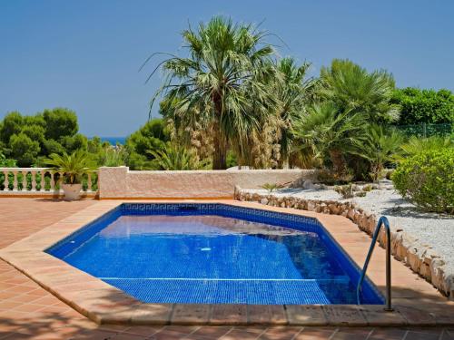 a swimming pool in a yard with palm trees at Apartment Gavrena by Interhome in Fanadix