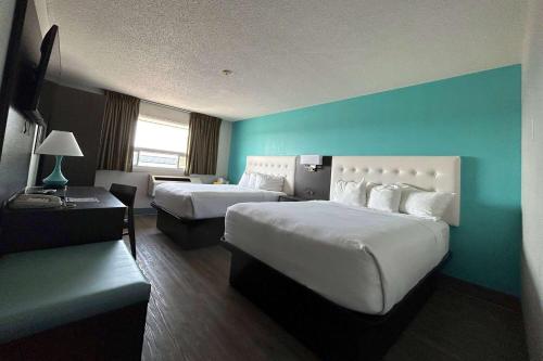 Habitación de hotel con 2 camas y pared azul en Howard Johnson by Wyndham Thunder Bay en Thunder Bay