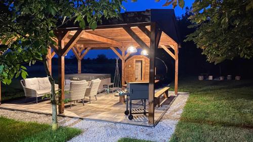 a wooden gazebo with a table and chairs at Siedlisko pod Kasztanem in Garwolin