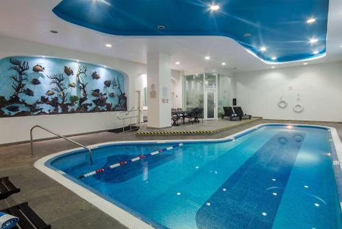 a large swimming pool with a blue ceiling at Ramada by Wyndham Ciudad de Mexico Perinorte in Mexico City