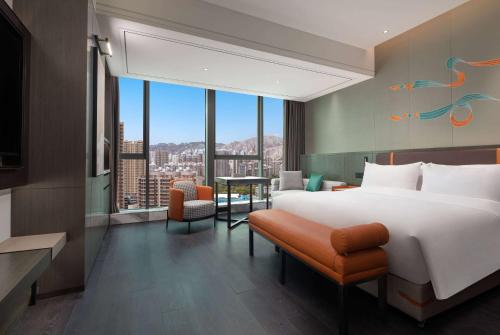 a hotel room with a large bed and a table at Wyndham Garden Lanzhou West Railway Station in Lanzhou