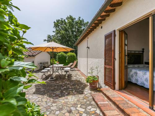 un patio con mesa y sombrilla en Holiday Home Mandorlo by Interhome, en Cinigiano