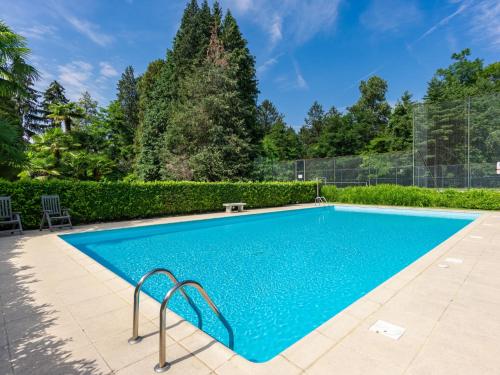 ein Swimmingpool mit blauem Wasser in einem Hof in der Unterkunft Apartment Euroville-6 by Interhome in Germignaga