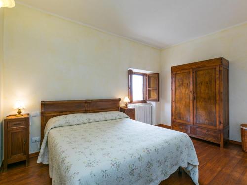 a bedroom with a bed and a wooden cabinet at Apartment Santa Marta by Interhome in Cinigiano