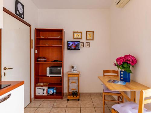 une cuisine avec une table, une table et un four micro-ondes dans l'établissement Apartment Euroville - LUI154 by Interhome, à Germignaga