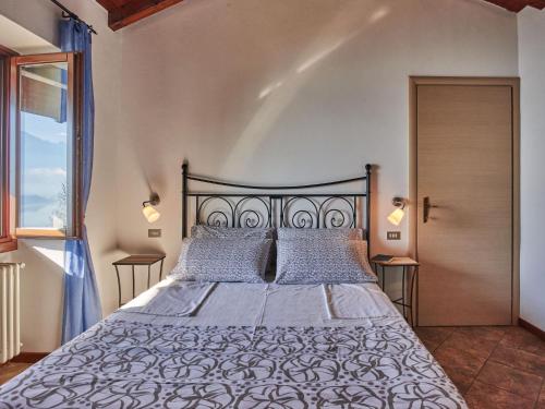 a bedroom with a large bed and a window at Holiday Home Rustico Simona - GRV255 by Interhome in Gravedona