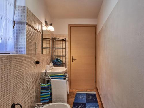 a bathroom with a sink and a toilet and a door at Holiday Home Rustico Simona - GRV255 by Interhome in Gravedona