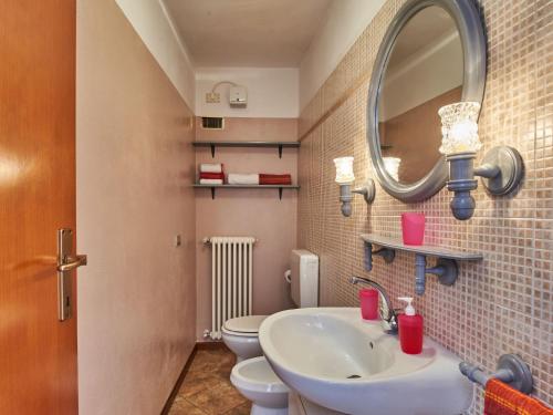 a bathroom with a sink and a mirror and a toilet at Holiday Home Rustico Simona - GRV255 by Interhome in Gravedona