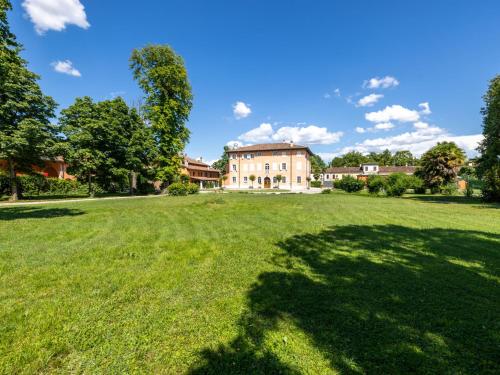 une grande cour herbeuse avec une maison en arrière-plan dans l'établissement Apartment Winery Villa Vitas - App- 5 by Interhome, à Strassoldo