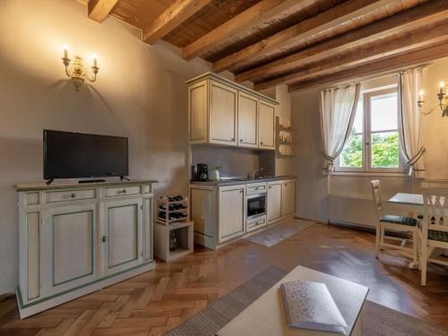 una cucina con armadi bianchi e un tavolo con televisore di Apartment Winery Villa Vitas - App- 5 by Interhome a Strassoldo