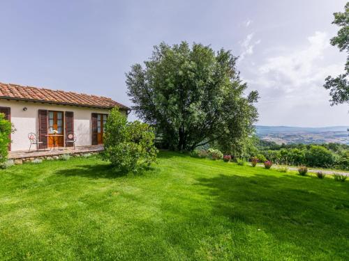 una casa con un giardino verde con un albero di Holiday Home Ciliegiolo by Interhome a Cinigiano