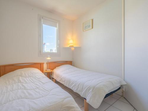 deux lits dans une chambre avec une fenêtre dans l'établissement Apartment Parc de Pontaillac-21 by Interhome, à Pontaillac