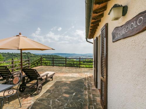 a patio with a table and chairs and an umbrella at Holiday Home Ciliegiolo by Interhome in Cinigiano