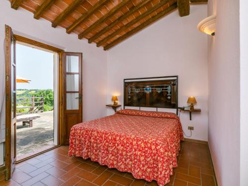 a bedroom with a bed and a large window at Holiday Home Ciliegiolo by Interhome in Cinigiano