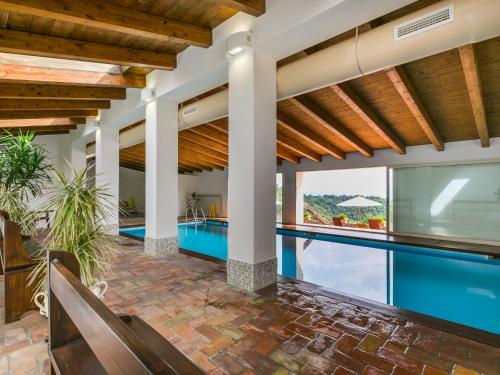 an indoor pool with a view of the ocean from a house at Holiday Home Ciliegiolo by Interhome in Cinigiano