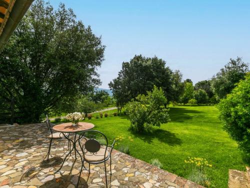 a table and chairs in a garden with a lawn at Holiday Home Ciliegiolo by Interhome in Cinigiano