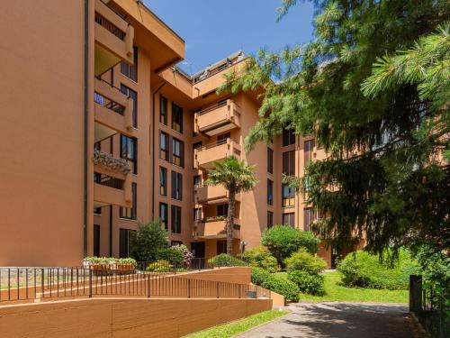 een appartementencomplex met een hek en bomen bij Apartment Gaggetto - LVM160 by Interhome in Laveno-Mombello