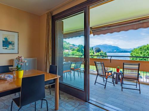 a dining room with a table and chairs and a balcony at Apartment Gaggetto - LVM160 by Interhome in Laveno-Mombello