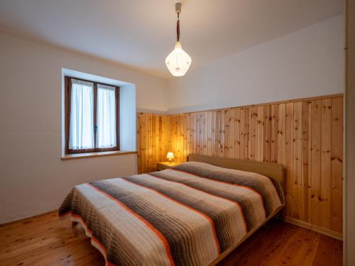 a bedroom with a bed with a wooden wall at Apartment Vetan by Interhome in Saint Nicolas
