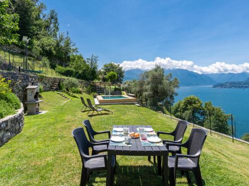 un tavolo e sedie su un prato con vista sull'acqua di Holiday Home Lacum Lux Resort by Interhome a Perledo