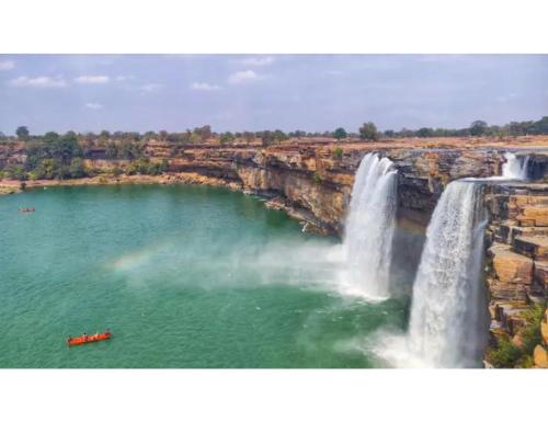 a view of a waterfall and a body of water at Hotel Raj, Chitrakoot in Sītāpur Mūāfi