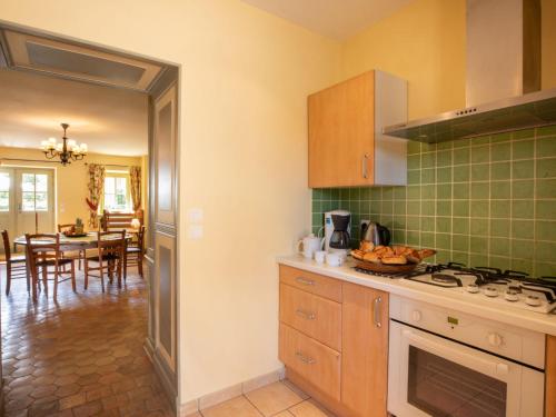 a kitchen with a stove and a dining room at Holiday Home La Maison du Chateau by Interhome in La Tagnière