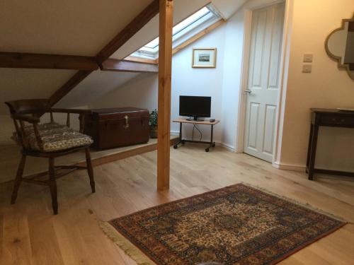 a living room with a chair and a rug and a window at Dwynant - A Room with a View in Llangathen