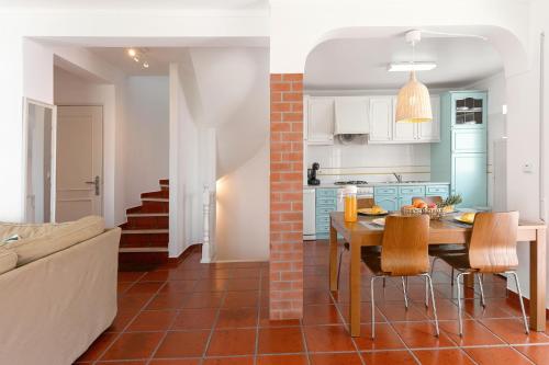 cocina y sala de estar con mesa y sillas en Villa Juno, en Atouguia da Baleia