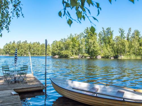 a boat on a dock with a table on the water at Holiday Home Lidelund by Interhome in Tingsryd