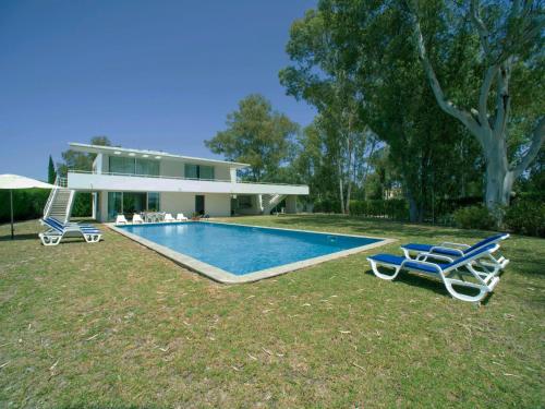 a house with a swimming pool and two lounge chairs at Holiday Home Villa Golf by Interhome in Portimão