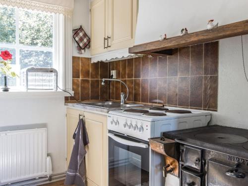 a kitchen with a white stove and a sink at Holiday Home Lidelund by Interhome in Tingsryd