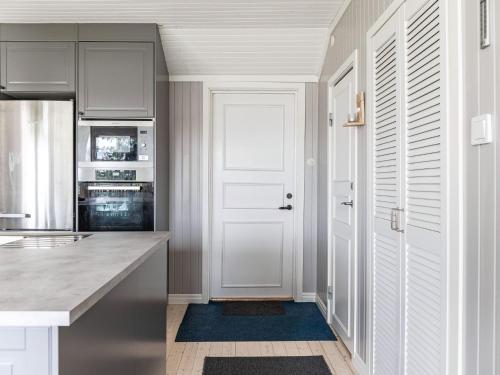 a kitchen with white cabinets and a white door at Holiday Home Gapern by Interhome in Killstad