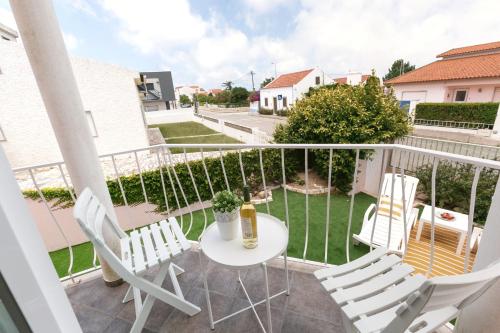 a balcony with a table and chairs and a yard at Villa Juno in Atouguia da Baleia