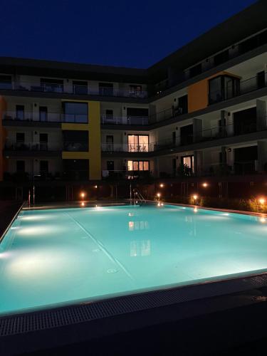 ein leerer Pool vor einem Gebäude in der Nacht in der Unterkunft Chill Panorama Apartman in Siófok