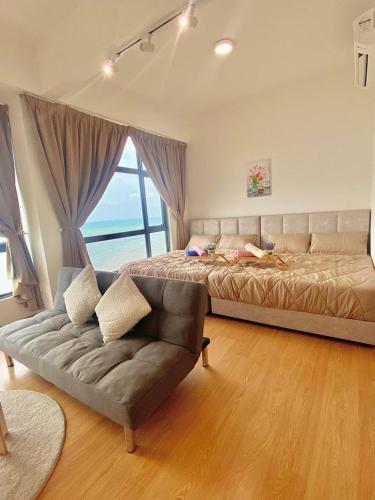 a bedroom with a bed and a couch and a window at imperium residence kuantan in Kuantan