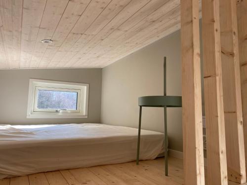 a bedroom with a bed and a window at Modern stuga med 1 sovrum och 1 sovloft med stor terrass och vedeldad bastu mitt på Österlen in Smedstorp