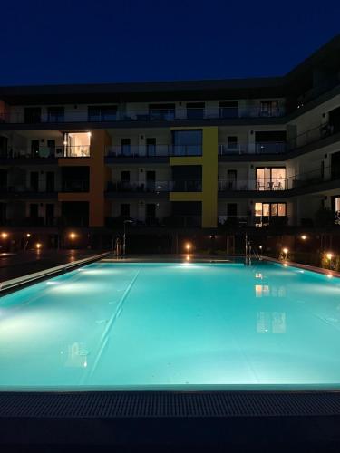 ein leerer Pool vor einem Gebäude in der Nacht in der Unterkunft Chill Panorama Apartman in Siófok