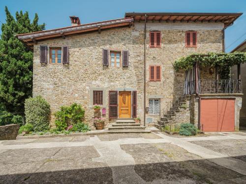 a stone house with a red door and stairs at Holiday Home Sara by Interhome in Gello