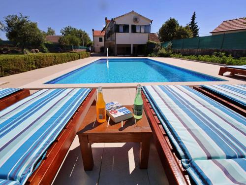 a swimming pool with a table and drinks on a bench at Holiday Home Bili dvori by Interhome in Čaporice