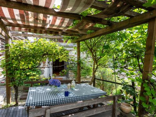 a picnic table under a pergola in a garden at Chalet Il Gianlupo by Interhome in Bognanco