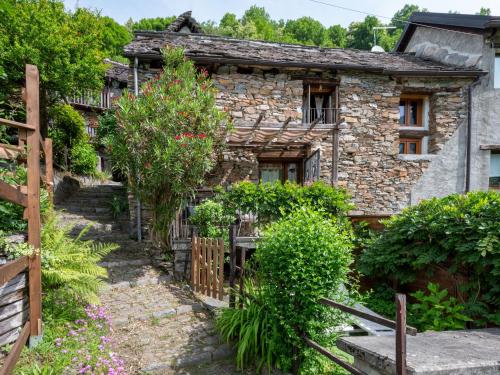 an old stone house with a garden in front of it at Chalet Il Gianlupo by Interhome in Bognanco