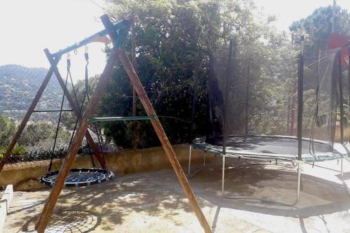 a swing set on a patio with a view at Wonderful house in the mountains with sea views in Cabrils
