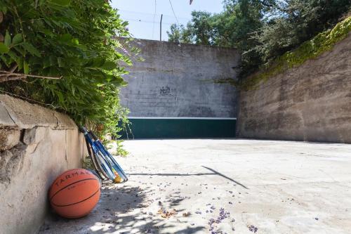 a basketball and rackets sitting next to a wall at Wonderful house in the mountains with sea views in Cabrils