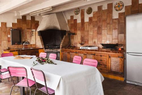 a kitchen with a white table and pink chairs at Wonderful house in the mountains with sea views in Cabrils