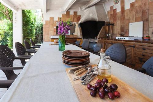 uma mesa longa com pratos e um vaso de flores em Wonderful house in the mountains with sea views em Cambrils