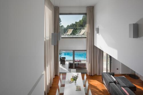 un soggiorno con tavolo e sedie bianchi di Villa Valsavia, apartment Valsavia with pool and SPA a Rovigno (Rovinj)