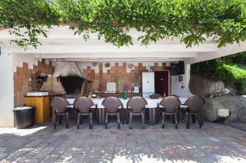 a group of chairs sitting around a table in a patio at Wonderful house in the mountains with sea views in Cabrils