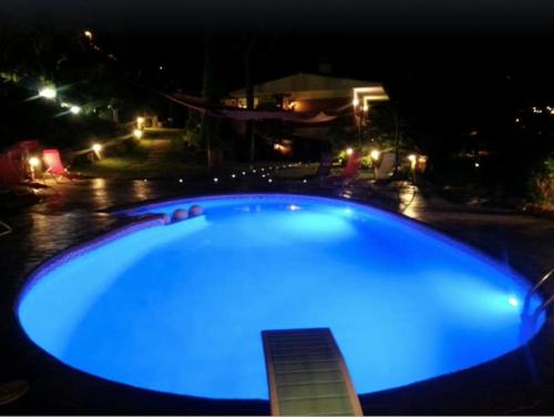 a blue swimming pool at night with a house at Wonderful house in the mountains with sea views in Cabrils